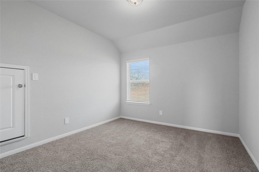 Perfect for guests or a quiet home office, this room features soft plush carpeting, a window with fitted blinds, sloped ceiling, and ample sized closet space.