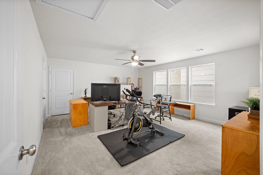 The third-floor bedroom is genuinely oversized — vaulted ceiling, plush carpet, ceiling fan, and en suite bath through that door. A flex space that works as a fourth bedroom, home office, or private guest suite. The third-floor bedroom is genuinely oversized — vaulted ceiling, plush carpet, ceiling fan, and en suite bath through that door. A flex space that works as a fourth bedroom, home office, or private guest suite.