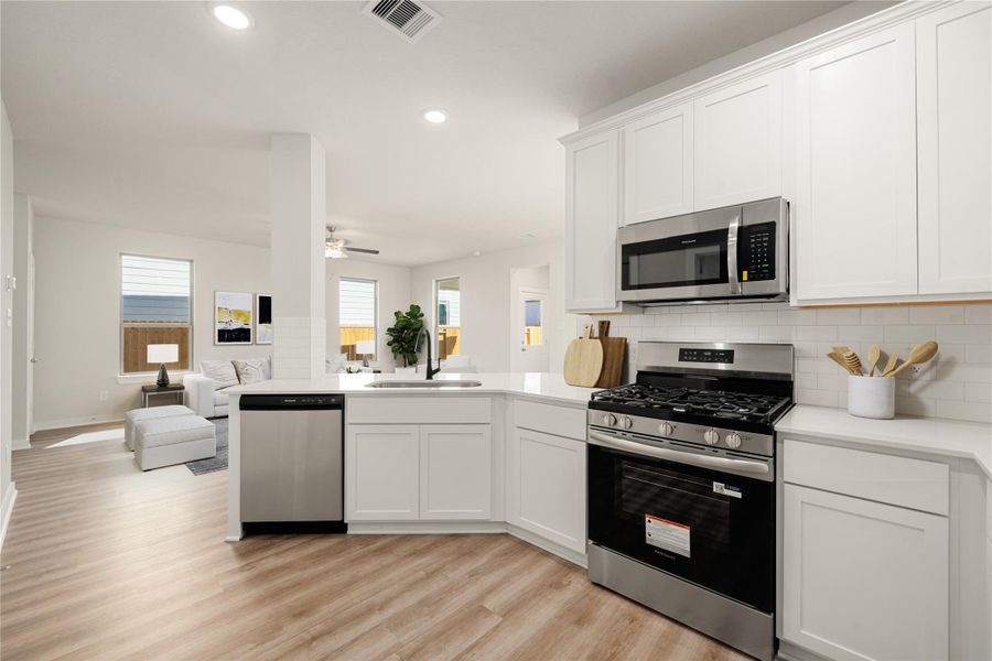 The bright and contemporary kitchen features sleek cabinetry, stainless steel appliances, quartz countertops, and a spacious breakfast bar that overlooks the main living area. The open layout and clean design make it both functional and inviting. The bright and contemporary kitchen features sleek cabinetry, stainless steel appliances, quartz countertops, and a spacious breakfast bar that overlooks the main living area. The open layout and clean design make it both functional and inviting.