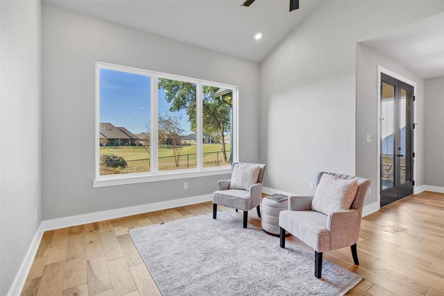 Living area featuring vaulted ceiling, light wood-type flooring, french doors, recessed lighting, and ceiling fan Living area featuring vaulted ceiling, light wood-type flooring, french doors, recessed lighting, and ceiling fan
