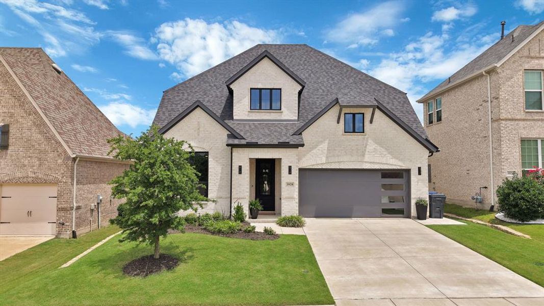 Contemporary-style residence featuring a light brick facade and dark trim accents Contemporary-style residence featuring a light brick facade and dark trim accents
