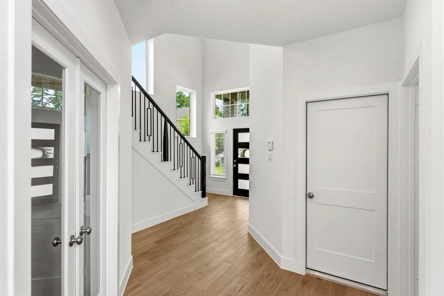 Entry branches off into a hallway with access to the garage and home office