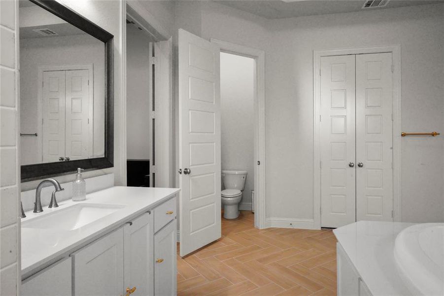 Full bathroom with vanity, a closet, and a bathtub Full bathroom with vanity, a closet, and a bathtub