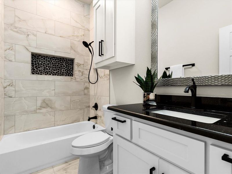 Bathroom featuring vanity, bathing tub / shower combination, and marble finish flooring