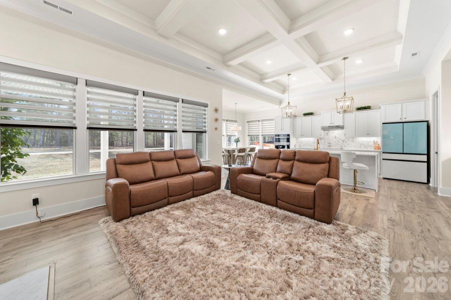 Spacious Great Room with Coffered Ceiling, Sustainable Wood Laminate Floors and Custom Window Treatments