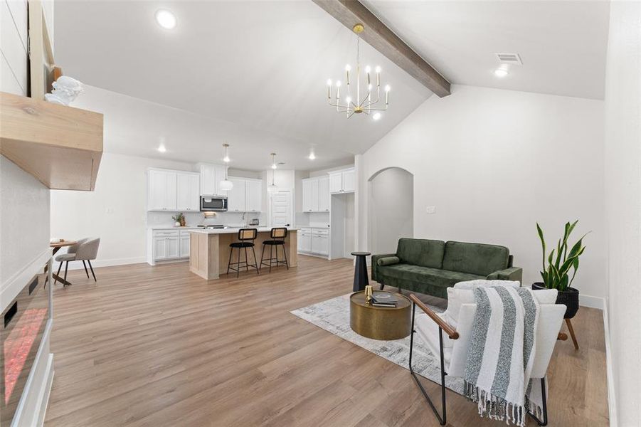 Living room with a chandelier, recessed lighting, baseboards, light wood-style floors, and arched walkways Living room with a chandelier, recessed lighting, baseboards, light wood-style floors, and arched walkways