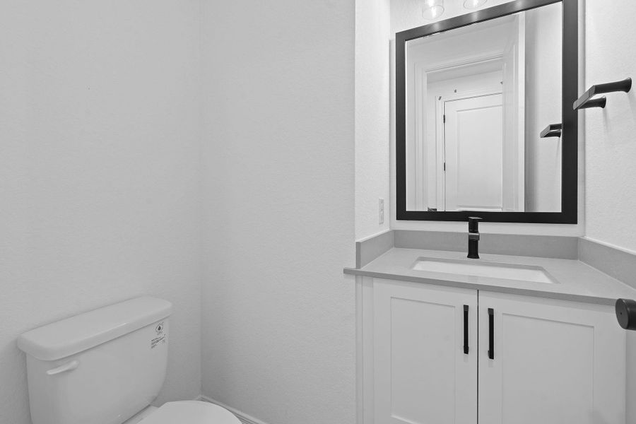 Half bathroom featuring vanity and toilet Half bathroom featuring vanity and toilet