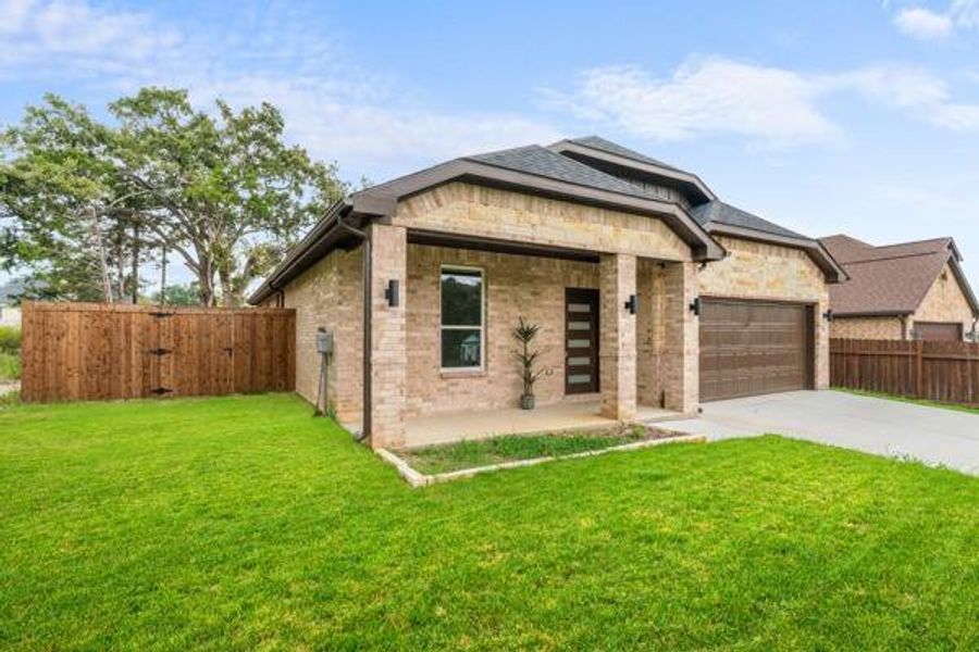 View of front of house with concrete driveway, brick siding, a garage, and a porch View of front of house with concrete driveway, brick siding, a garage, and a porch