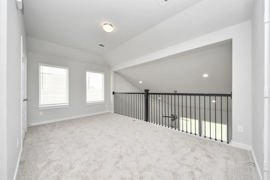 Come upstairs and enjoy a day of leisure in this fabulous game room! This is the perfect hangout spot or adult game room! Features plush carpet, high ceilings, custom paint and windows for plenty of natural light. Sample photo of completed home with similar floor plan. Actual colors and selections may vary.