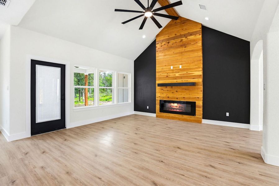 Vaulted ceilings complement an inviting modern fireplace, setting a refined tone for this well-lit living area.