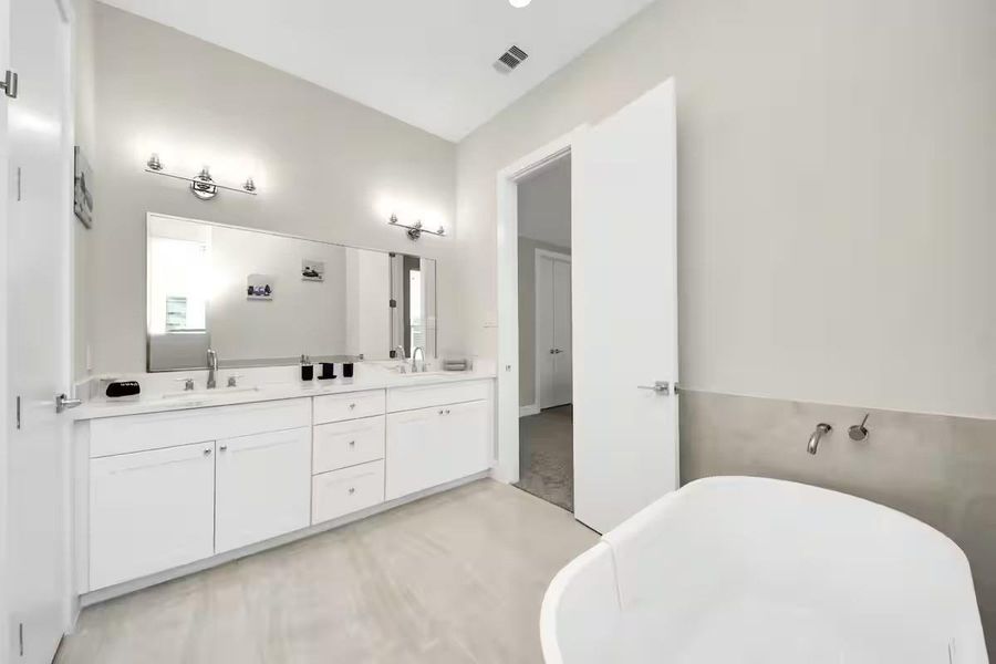 Start and end the day with room to spread out. The primary bath offers an extended vanity, generous storage, and a freestanding soaking tub.