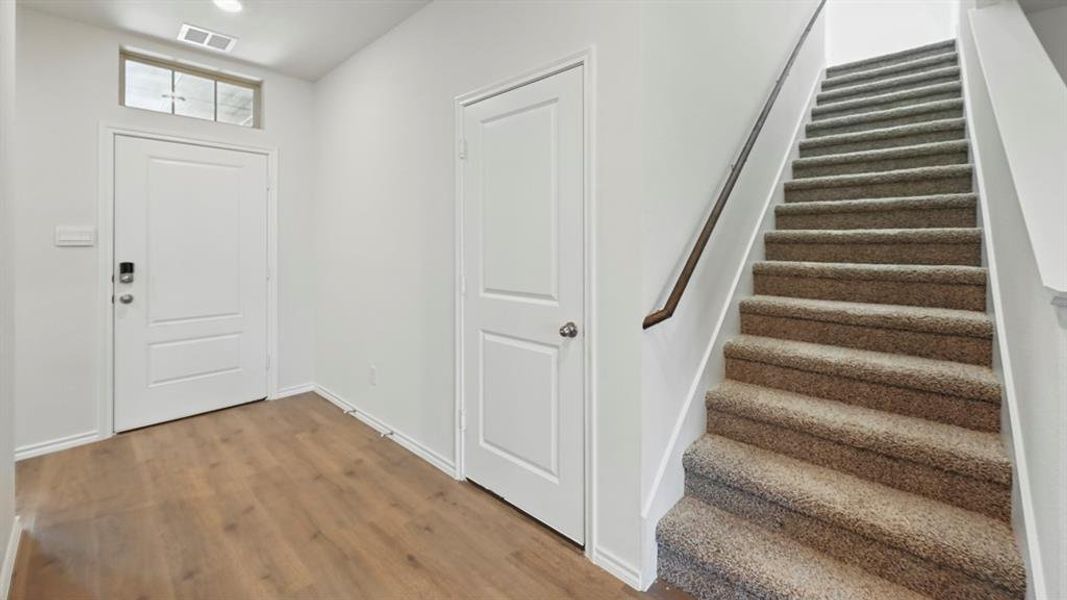 Entryway with stairway and wood finished floors