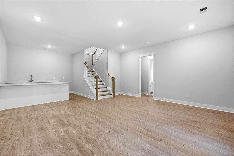 Polished wood floors and recessed lighting enhance
