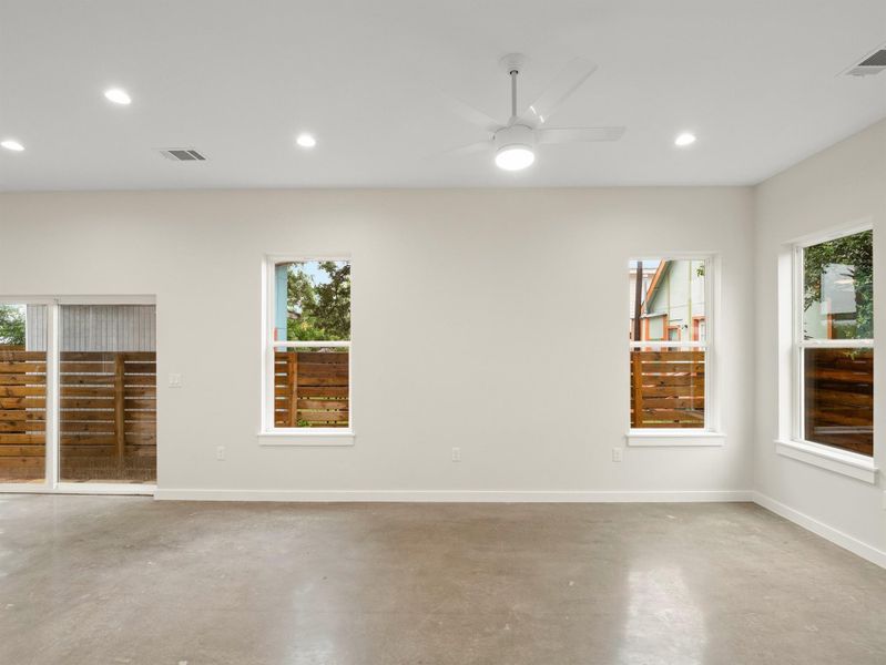 Spacious interior with polished concrete flooring and multiple windows providing ample natural light