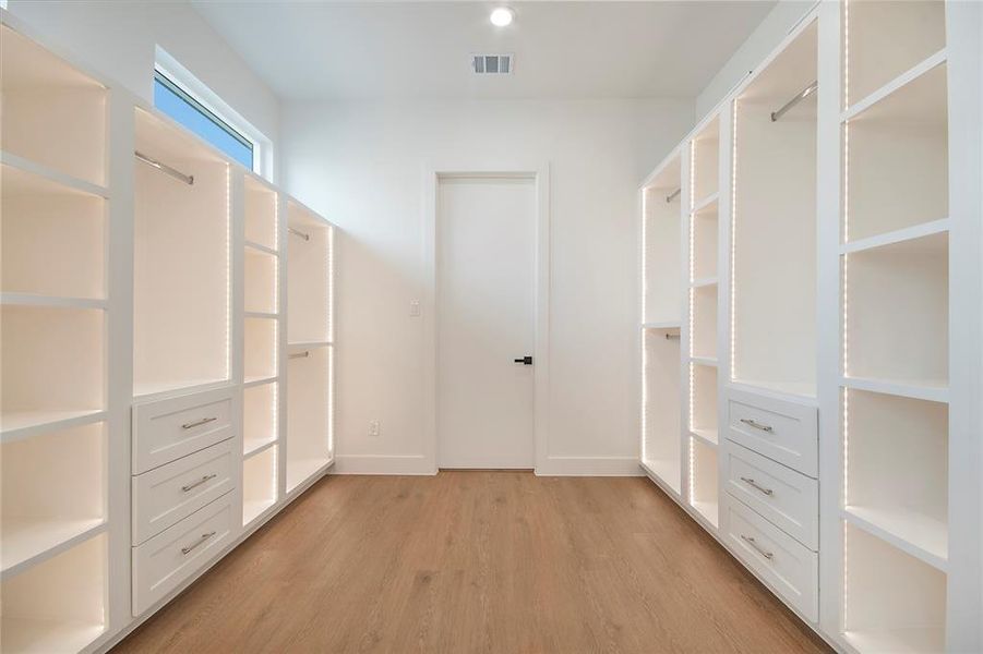 Walk in closet with light wood-style floors