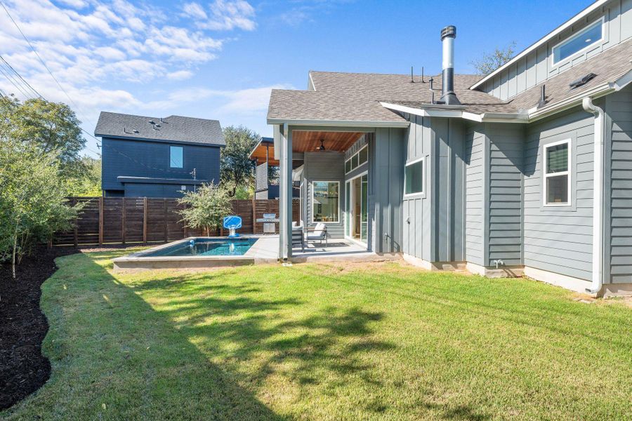 Back of property featuring board and batten siding, a patio, a fenced backyard, and roof with shingles