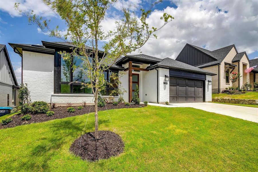 View of front of house with a front lawn and a garage