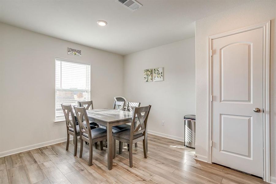 Dining area with light wood-type flooring and recessed lighting