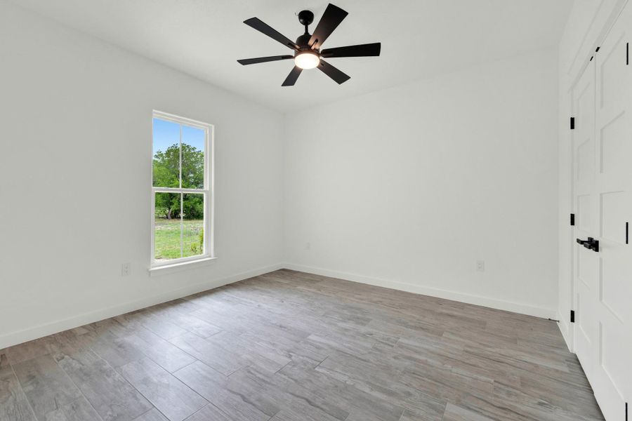 Bright room with wood-finish flooring and a contemporary black ceiling fan