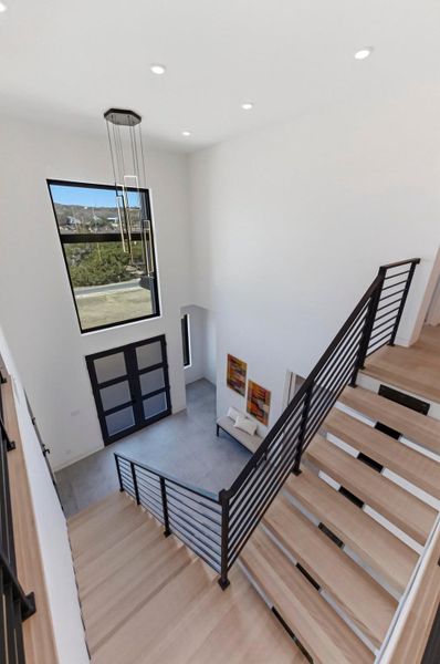 Staircase with recessed lighting and a high ceiling