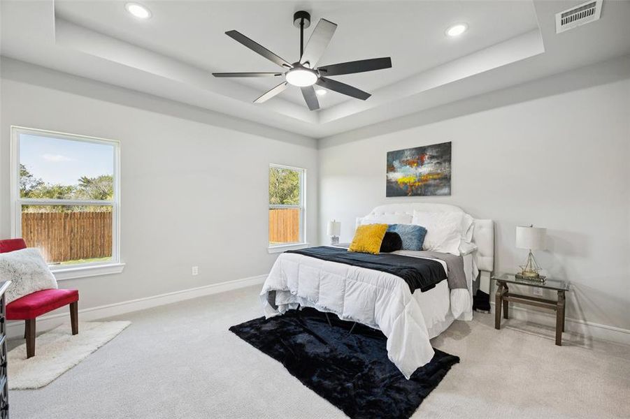Bedroom with a raised ceiling, carpet, a ceiling fan, and recessed lighting