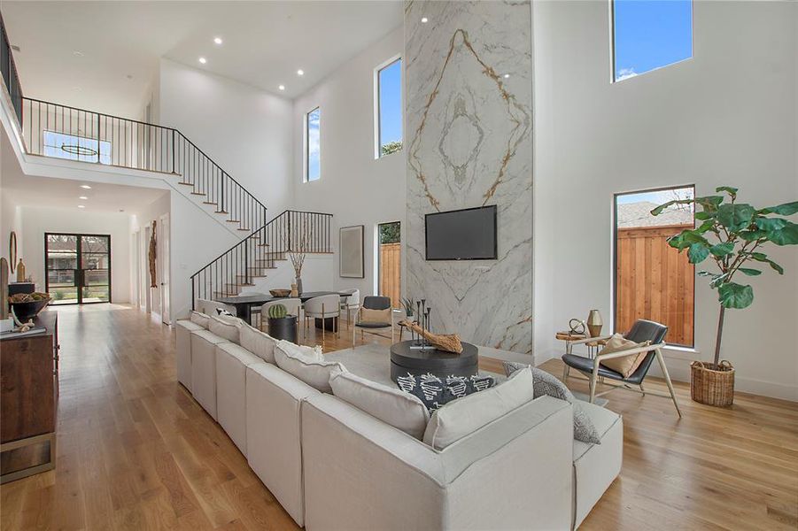 Living room featuring a towering ceiling and light hardwood / wood-style flooring