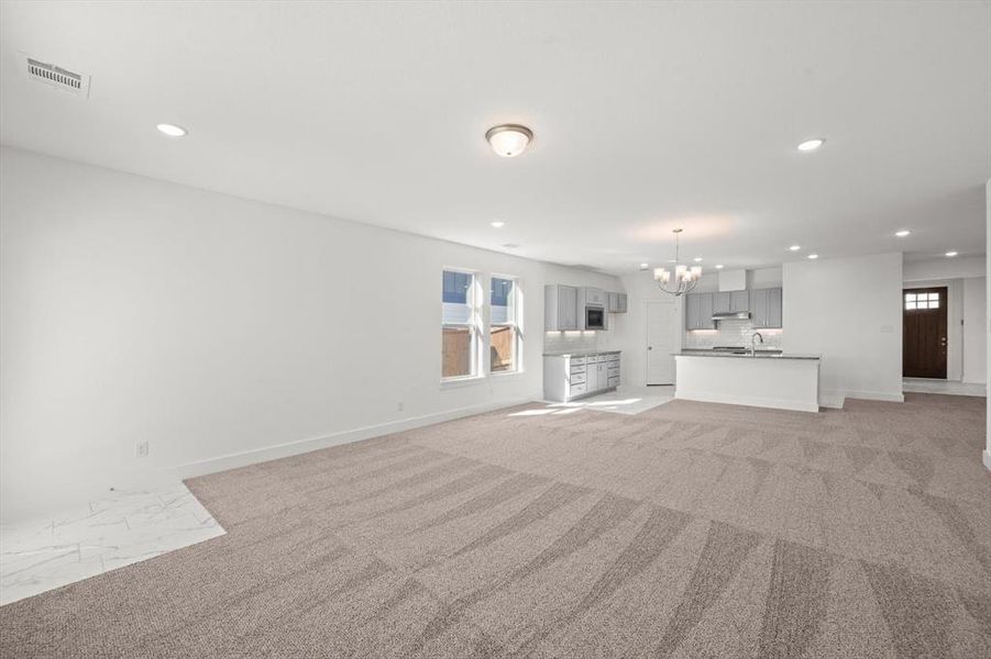 Living area with carpet flooring and lots of natural light