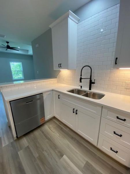 Gleaming white cabinetry and stainless steel appliances complete this bright, contemporary kitchen. Gleaming white cabinetry and stainless steel appliances complete this bright, contemporary kitchen.