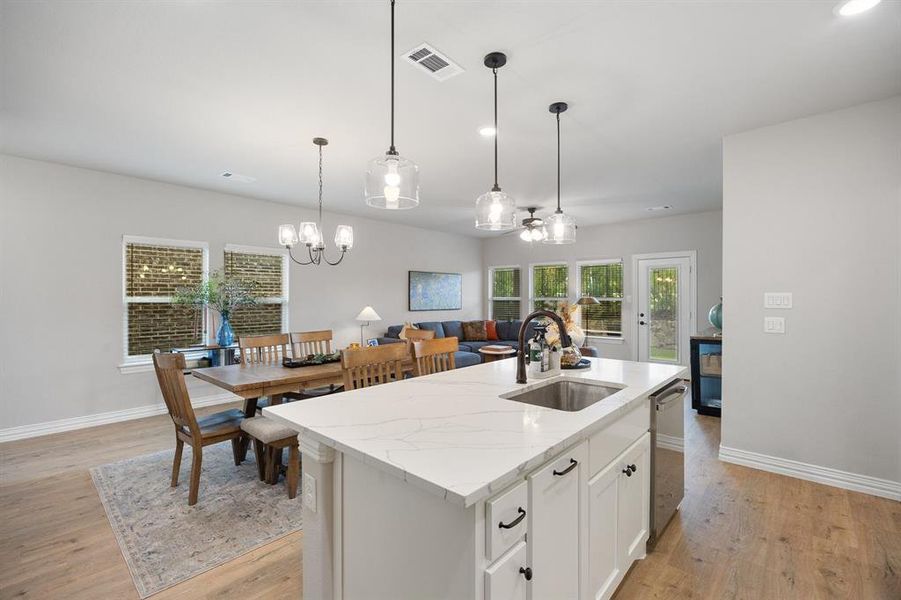 Kitchen with white cabinetry, light stone countertops, light wood finished floors, pendant lighting, and recessed lighting