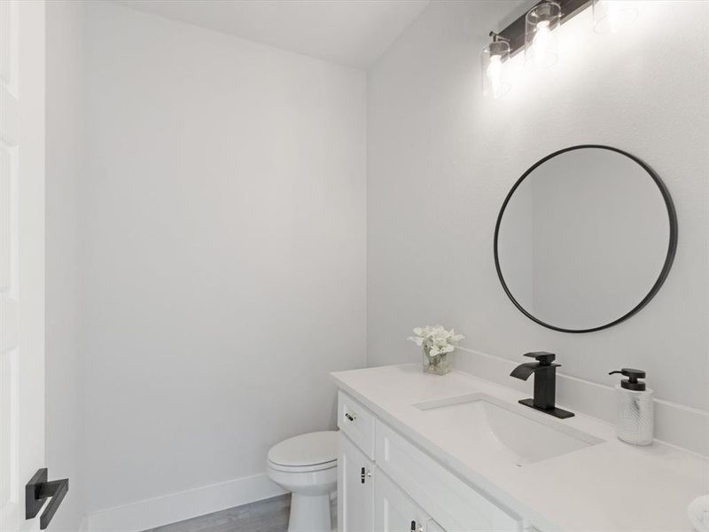 Bathroom with vanity, hardwood / wood-style flooring, and toilet