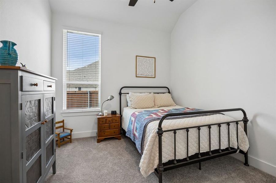 Carpeted room featuring a single window with blinds, a ceiling fan, and white walls Carpeted room featuring a single window with blinds, a ceiling fan, and white walls