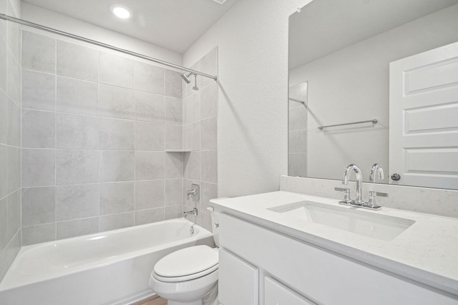 A bathroom with a tub sink and toilet.