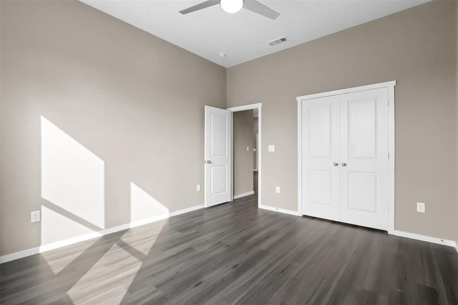 Unfurnished bedroom featuring ceiling fan, dark hardwood / wood-style flooring, and a closet