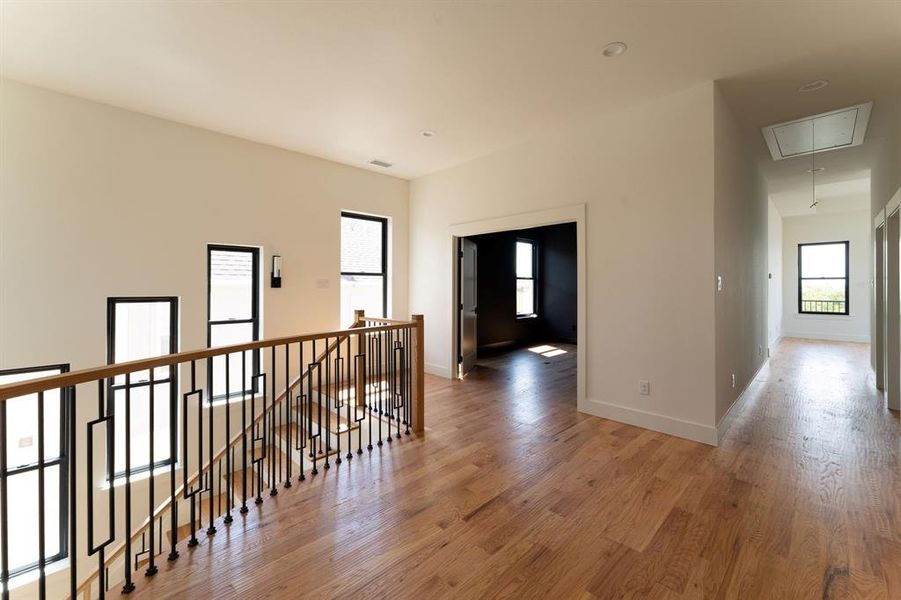 Hallway with attic access, an upstairs landing, light wood-style floors, and recessed lighting