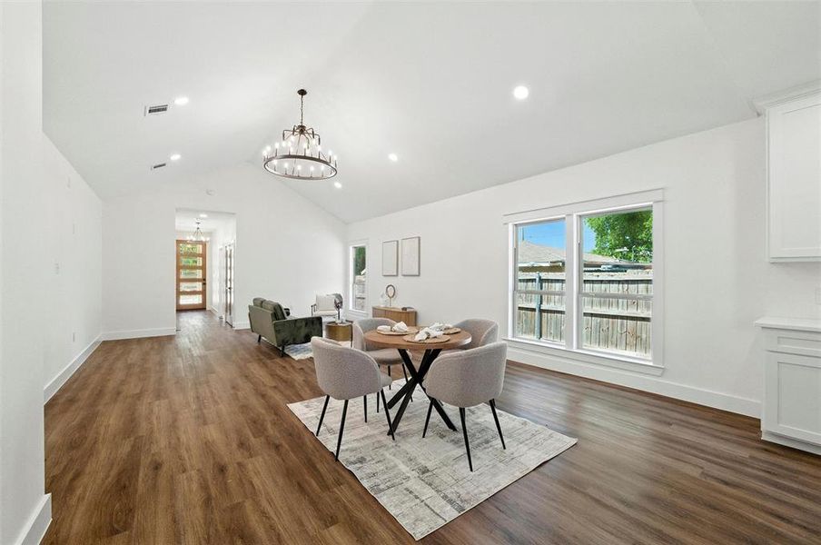 Dining area featuring a chandelier, dark wood-style floors, recessed lighting, and high vaulted ceiling