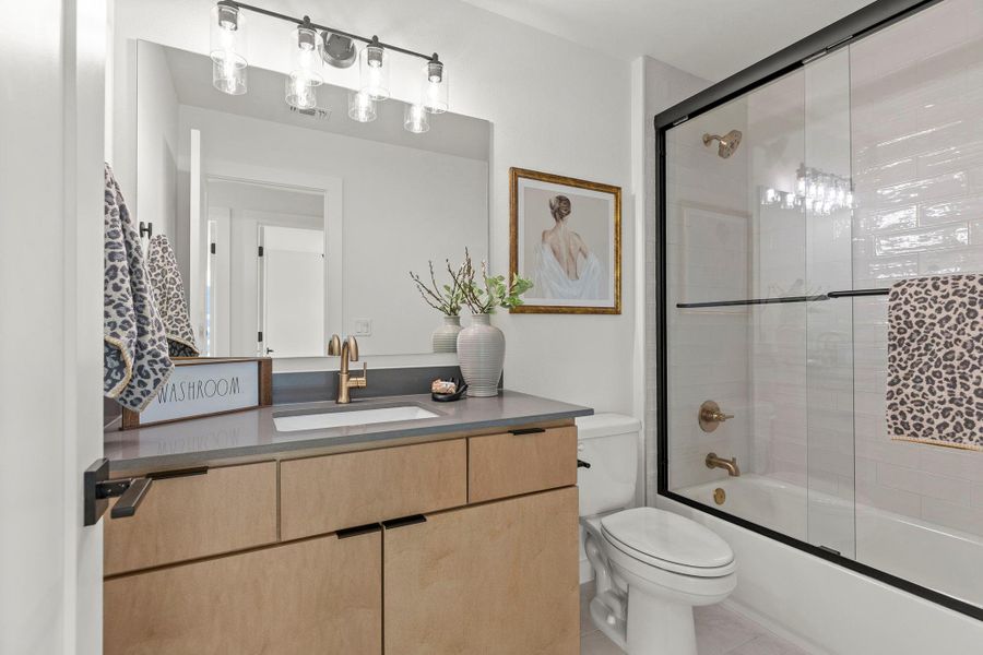 Full bath with shower / bath combination with glass door and vanity