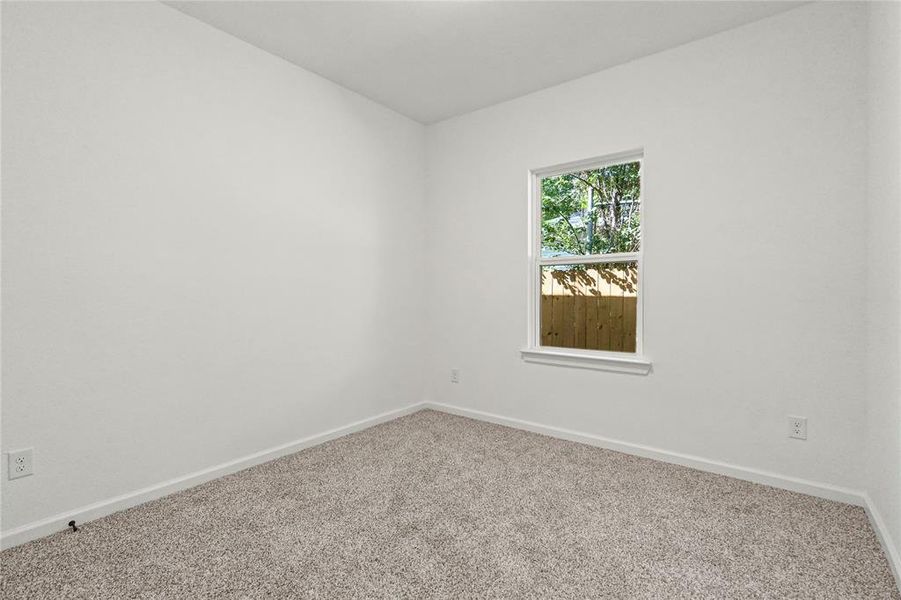 Spare room featuring carpet and baseboards
