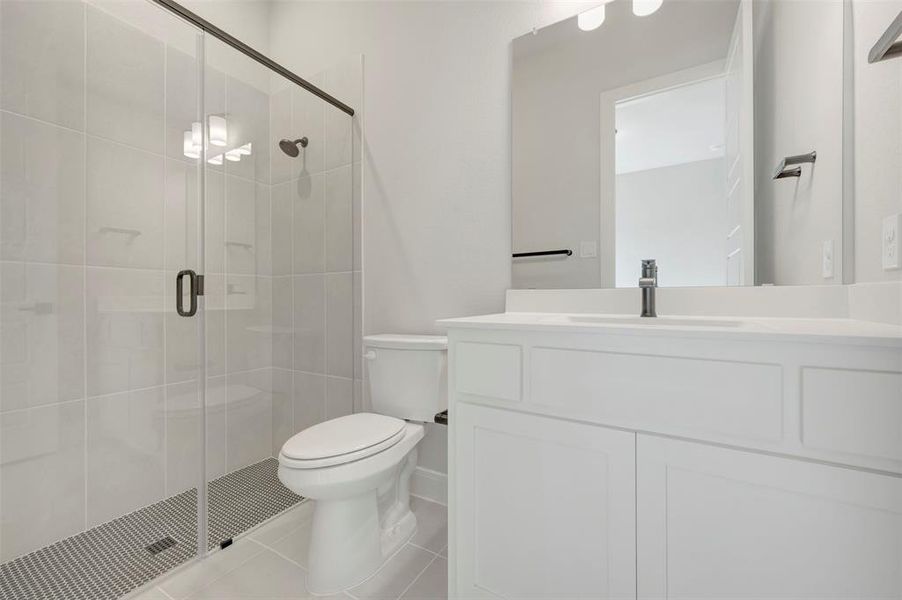Full bathroom with a shower stall, vanity, and light tile patterned floors