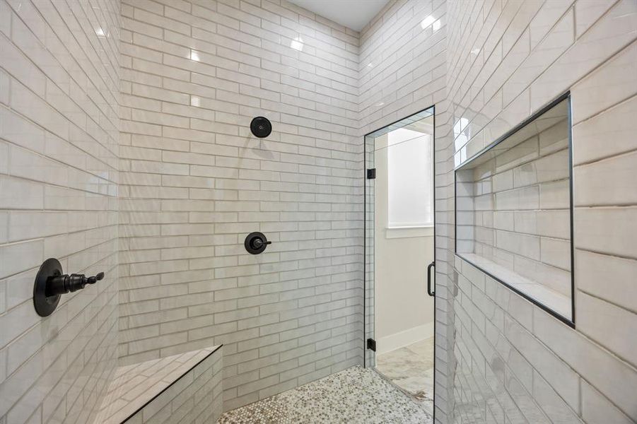 Bathroom featuring a stall shower and tile walls Bathroom featuring a stall shower and tile walls