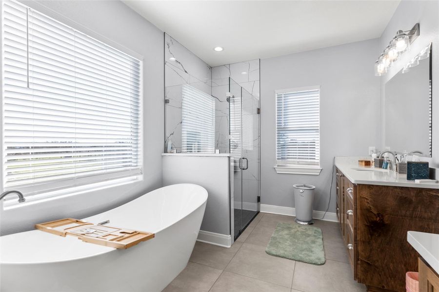 Primary Full bathroom featuring double vanity, a separate shower  light tile  floors, a freestanding soaking tub, and recessed lighting