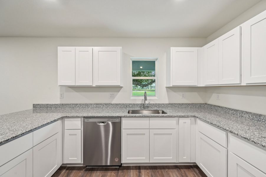 A kitchen with white cabinets.