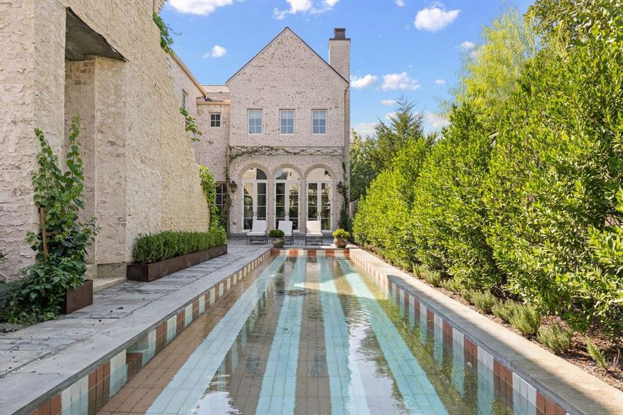 Back of property with a patio, a chimney, and brick siding