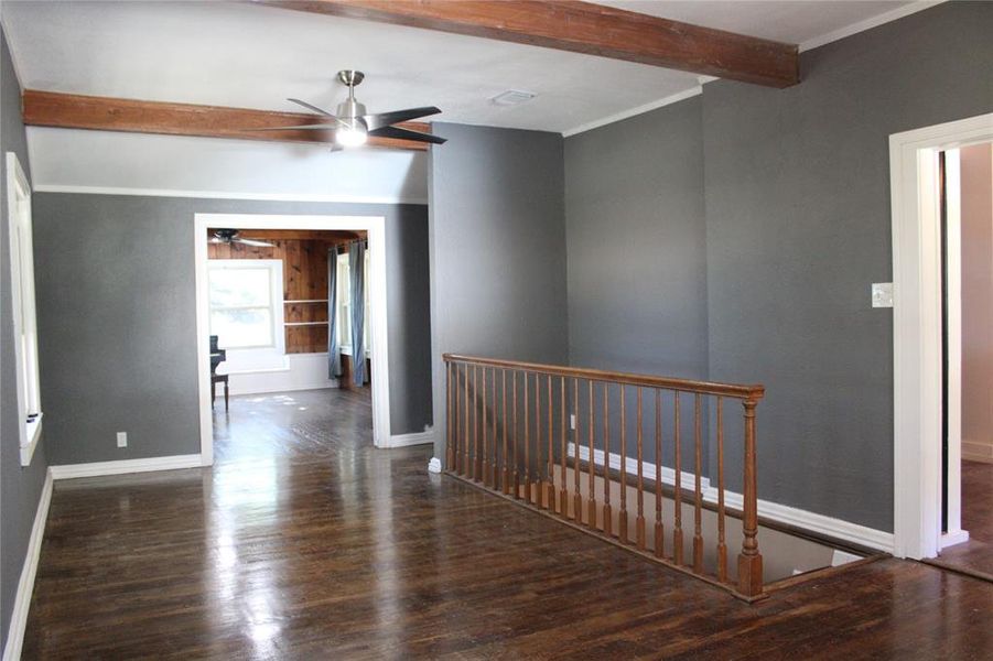 Hallway with beam ceiling, dark wood-style floors, and crown molding Hallway with beam ceiling, dark wood-style floors, and crown molding