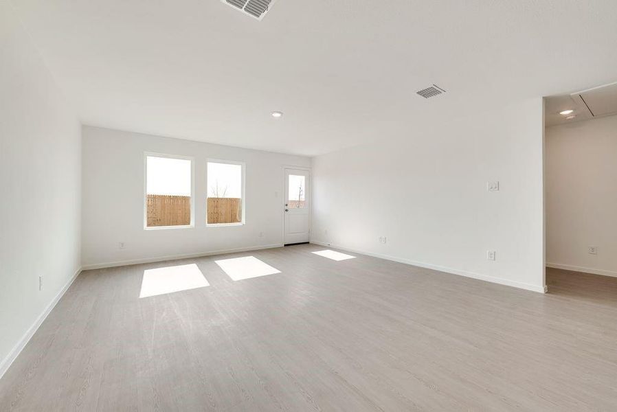 Unfurnished room featuring baseboards, light wood-style floors, visible vents, and attic access