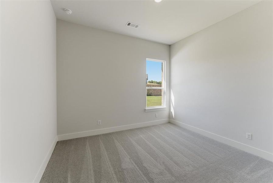Spare room featuring light carpet and baseboards