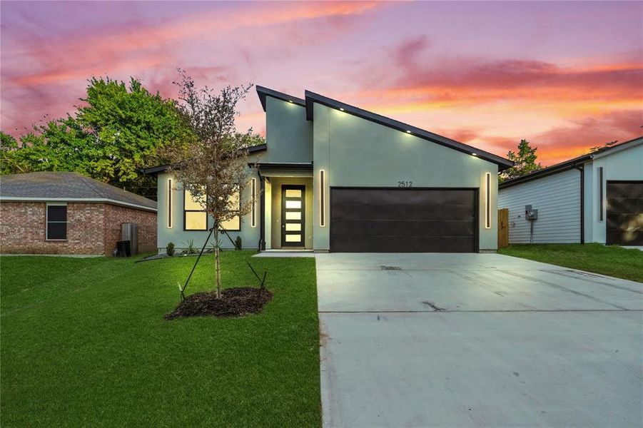 Contemporary house featuring driveway, stucco siding, a garage, and a front lawn Contemporary house featuring driveway, stucco siding, a garage, and a front lawn