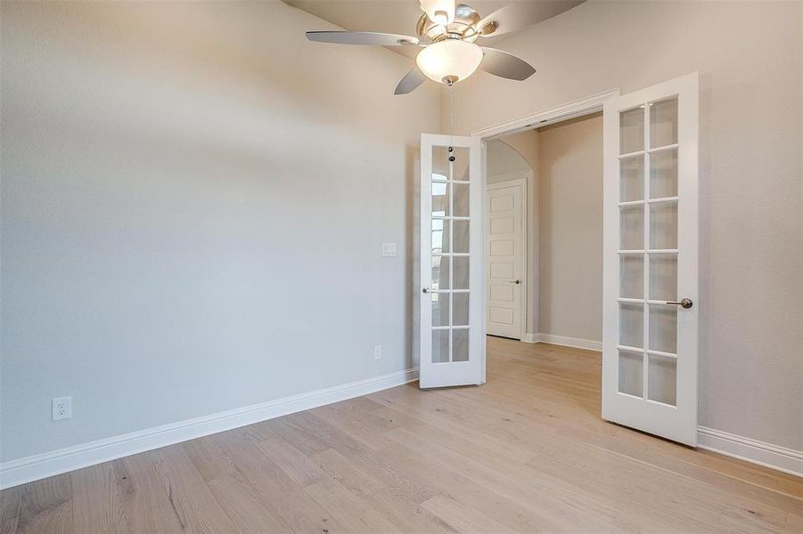 Spare room featuring ceiling fan, light wood-type flooring, and french doors