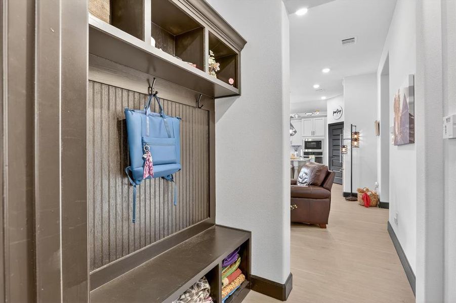 Built-in mudroom station with overhead cubbies, beadboard paneling, and integrated hooks