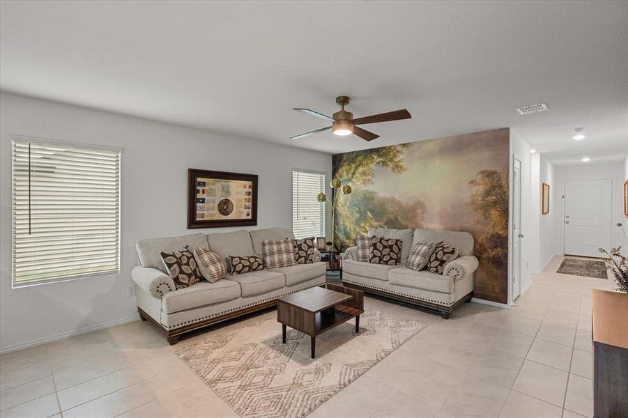 Living room featuring light tile patterned floors and a ceiling fan