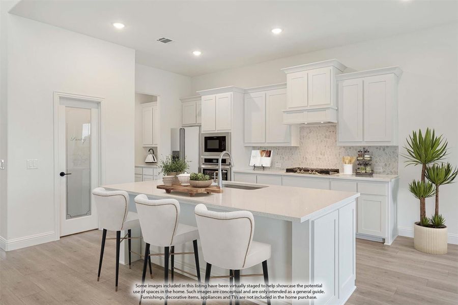 White kitchen with center island, bar seating, stainless appliances, and tile backsplash on light wood floors